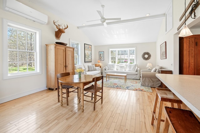 dining space with light wood-style flooring, a wall unit AC, a wealth of natural light, and vaulted ceiling