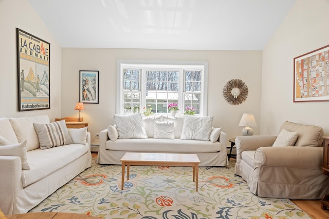 living area featuring a baseboard heating unit, light wood-type flooring, and lofted ceiling
