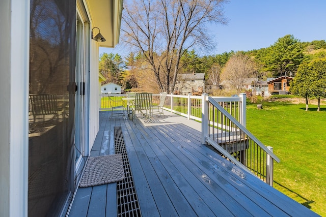 wooden terrace with a yard and outdoor dining space