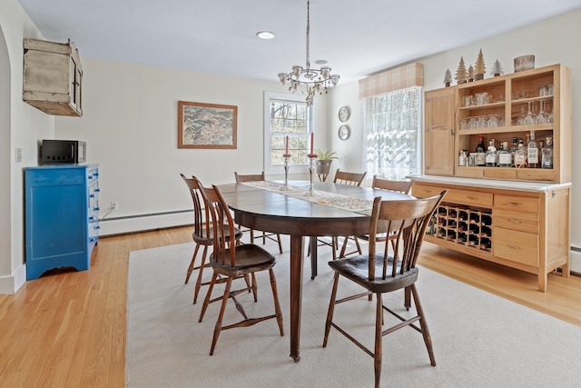 dining area with an inviting chandelier, light wood-style floors, baseboards, baseboard heating, and recessed lighting