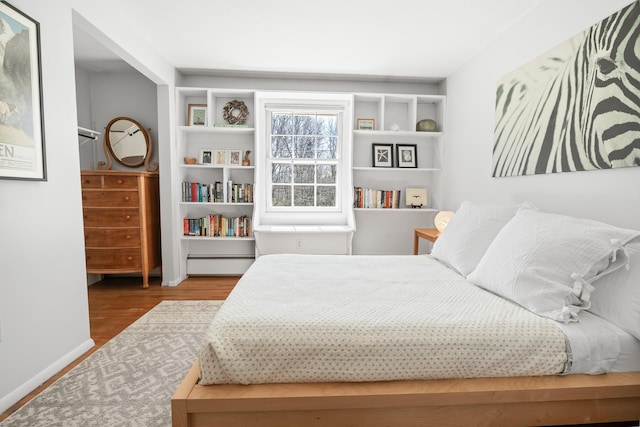 bedroom featuring baseboards and wood finished floors