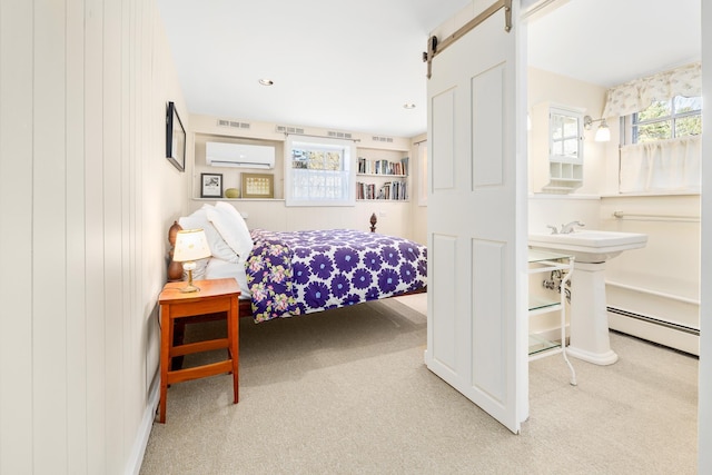 bedroom featuring visible vents, a wall mounted AC, baseboard heating, a barn door, and carpet flooring