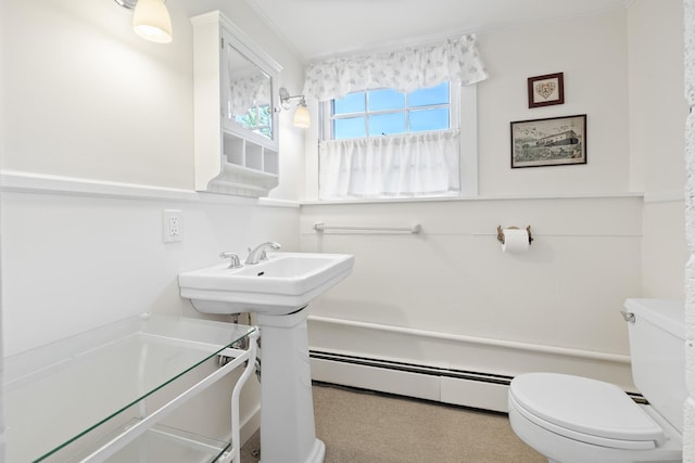 half bathroom with toilet and a baseboard heating unit