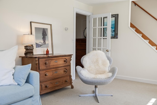 living area with light colored carpet and stairway