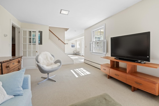 living area featuring stairs, light colored carpet, baseboards, and a baseboard heating unit