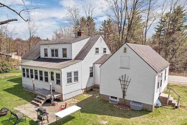 rear view of property with roof with shingles, a chimney, a yard, and cooling unit