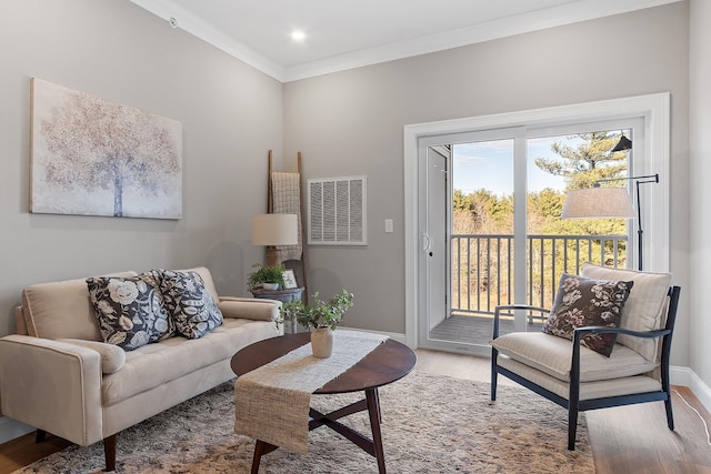 living area with visible vents, crown molding, wood finished floors, baseboards, and recessed lighting