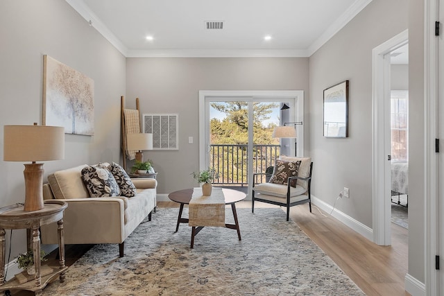 living area with light wood-style floors, a healthy amount of sunlight, and visible vents