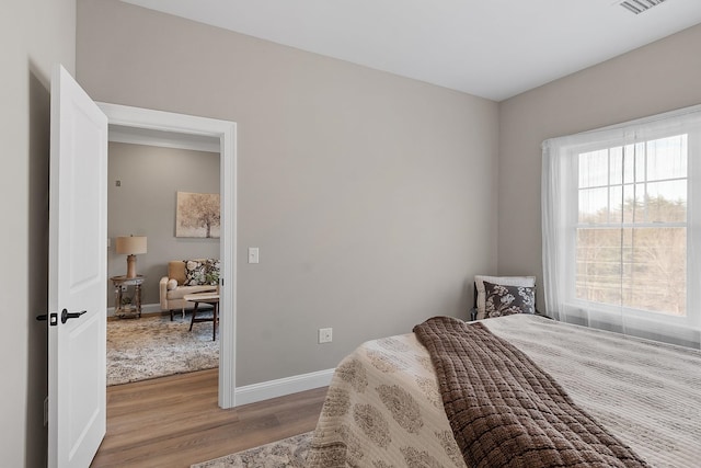 bedroom with baseboards and wood finished floors