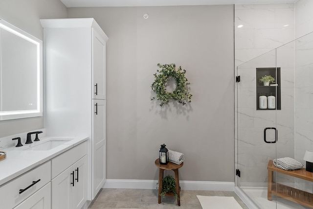 bathroom featuring vanity, baseboards, and a shower stall