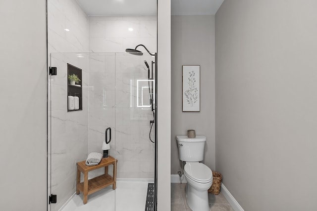 full bath featuring toilet, baseboards, tile patterned flooring, and a stall shower