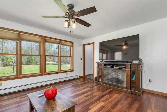 unfurnished living room featuring baseboards, ceiling fan, baseboard heating, and wood finished floors