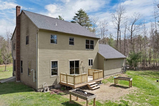 back of property with a shingled roof, a chimney, a yard, and a deck