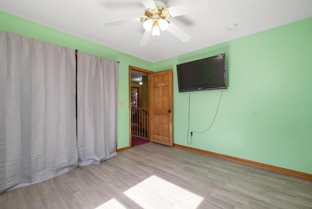 unfurnished bedroom with baseboards, a ceiling fan, and light wood finished floors