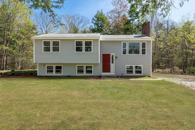 bi-level home with a front lawn and a chimney