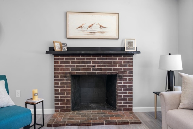 room details featuring baseboards, a fireplace, and wood finished floors
