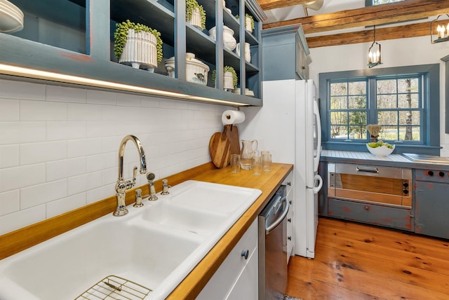 kitchen with decorative backsplash, open shelves, hardwood / wood-style flooring, dishwasher, and a sink