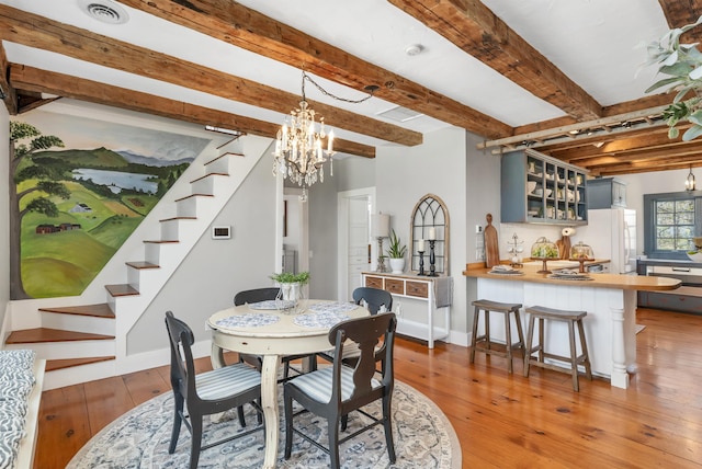 dining room featuring visible vents, beamed ceiling, stairway, light wood-type flooring, and a chandelier