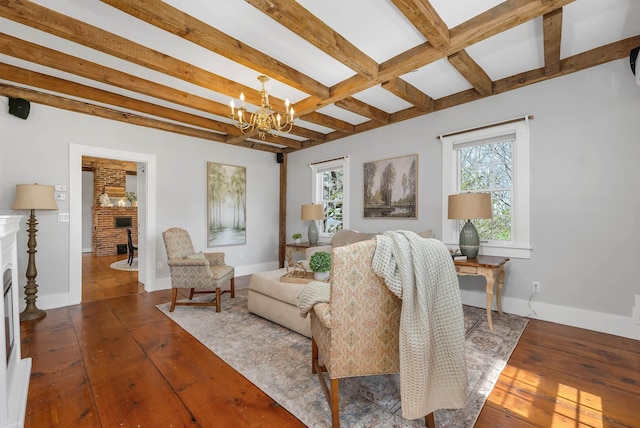 living area with a wealth of natural light, a chandelier, hardwood / wood-style floors, and beamed ceiling