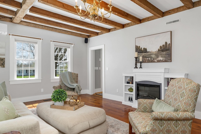 living area featuring visible vents, wood finished floors, beam ceiling, baseboards, and an inviting chandelier