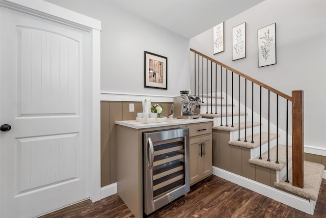 bar featuring indoor wet bar, dark wood-style flooring, stairway, and wine cooler