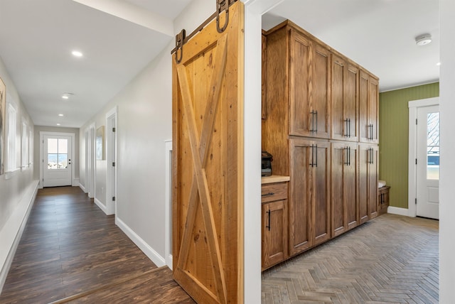 corridor with recessed lighting, baseboards, a barn door, and parquet floors