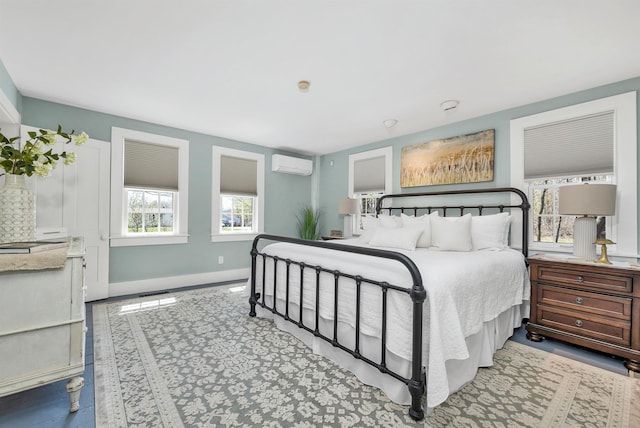 bedroom with baseboards and a wall mounted AC