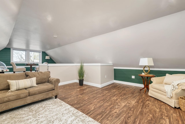 living area featuring baseboards, lofted ceiling, and wood finished floors
