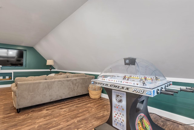 recreation room featuring baseboards, wood finished floors, and lofted ceiling