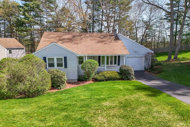 view of front of home with a shingled roof, an attached garage, a front yard, and aphalt driveway