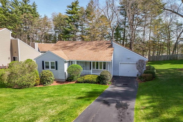 view of front of property with a porch, a front yard, a garage, fence, and aphalt driveway