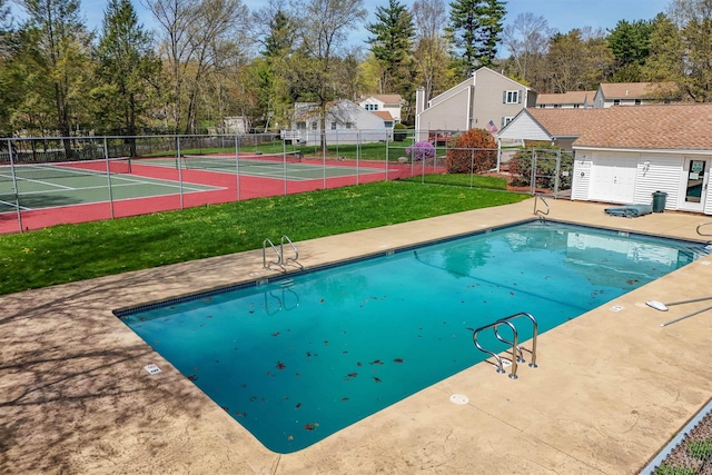 pool featuring fence, a yard, and a tennis court