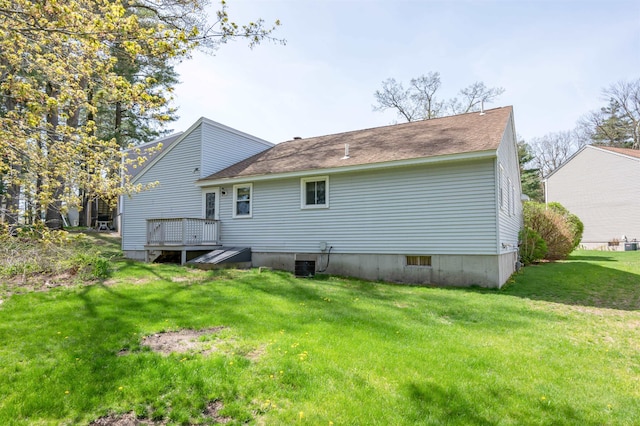 back of property with a lawn, a deck, a shingled roof, and central air condition unit