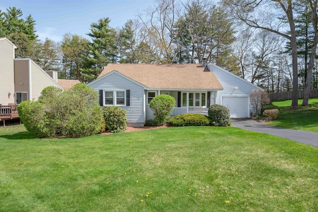 ranch-style home with a garage, a shingled roof, aphalt driveway, and a front yard