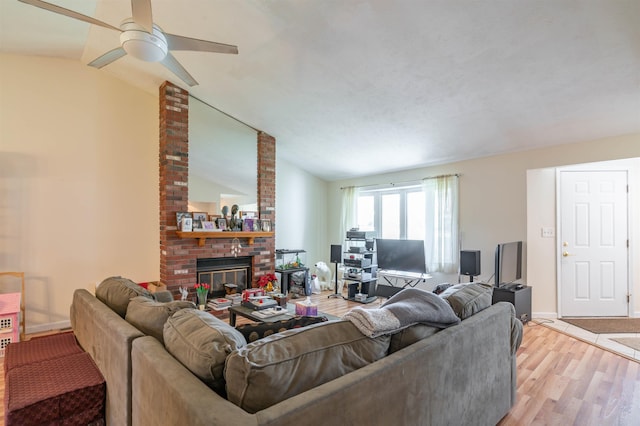 living room featuring light wood-type flooring, a brick fireplace, ceiling fan, and lofted ceiling