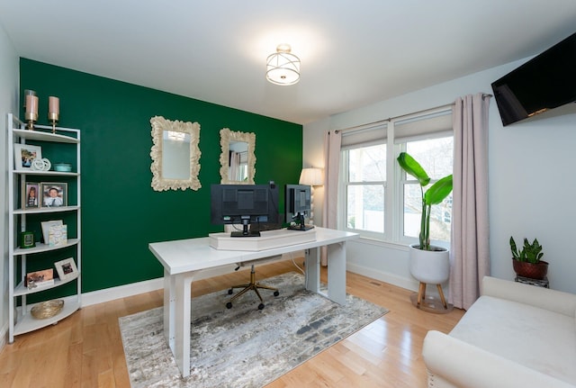 office space featuring baseboards and light wood finished floors