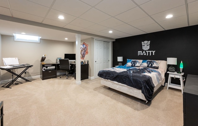 carpeted bedroom with recessed lighting, baseboards, a drop ceiling, and a closet