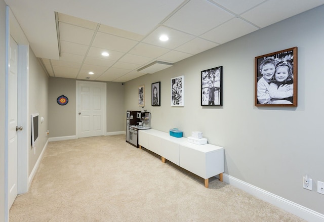 interior space featuring baseboards, light carpet, a drop ceiling, and recessed lighting