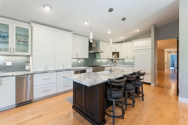kitchen with white cabinets, high quality appliances, a sink, and tasteful backsplash