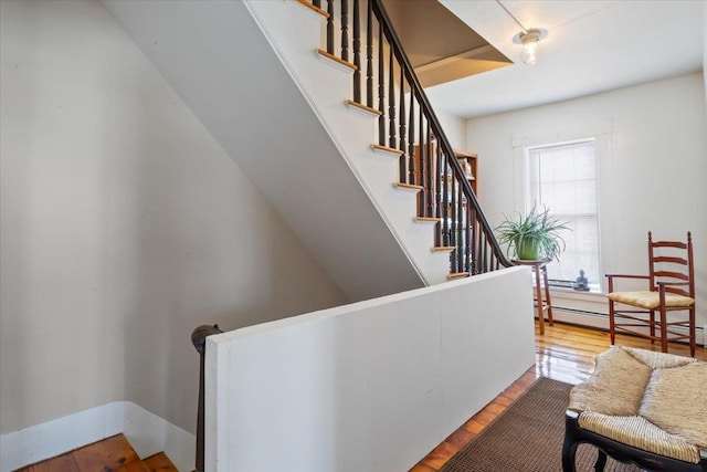 16 Manchester St Unit 2, Pittsfield, NH 03263 - staircase featuring a baseboard heating unit and wood finished floors