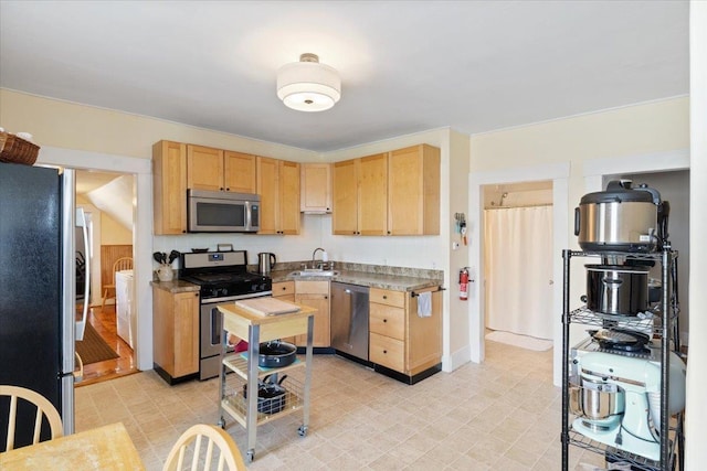 16 Manchester St Unit 2, Pittsfield, NH 03263 - kitchen featuring light brown cabinetry, washer and dryer, appliances with stainless steel finishes, a sink, and baseboards