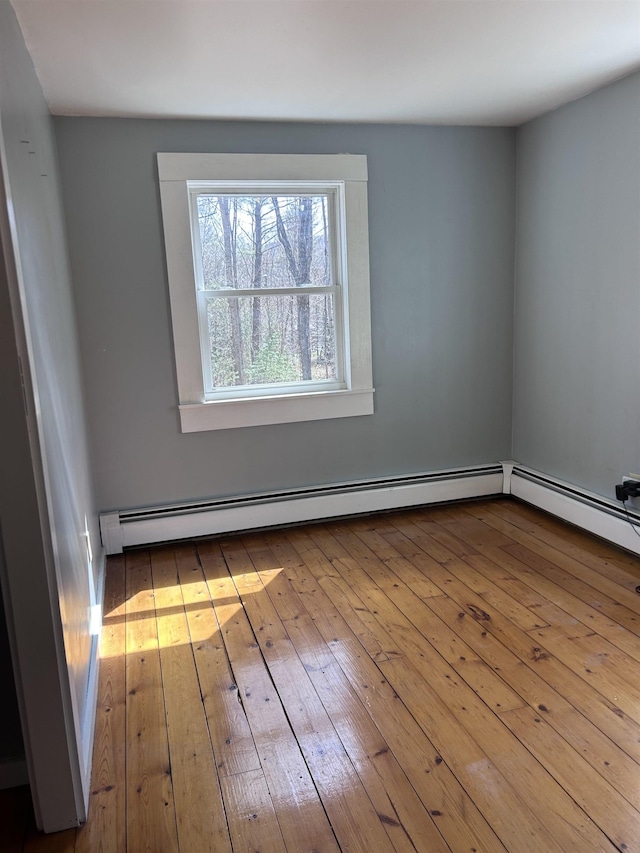 spare room featuring a baseboard radiator and hardwood / wood-style floors