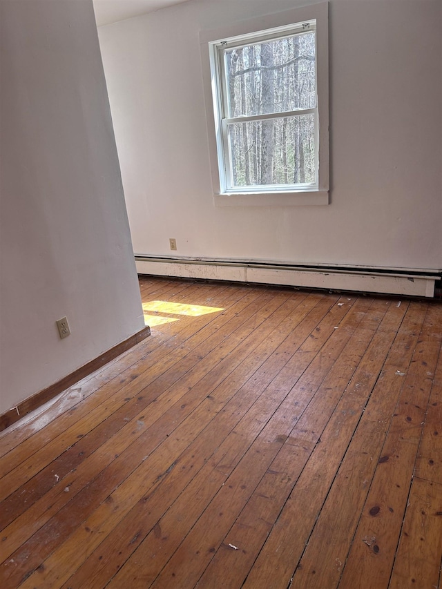 spare room with baseboard heating and hardwood / wood-style flooring