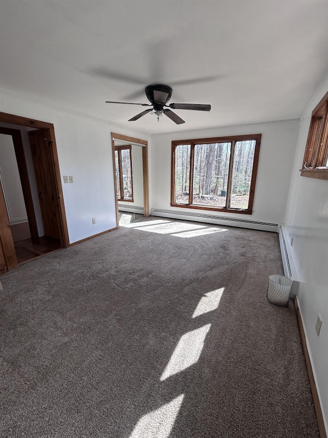 empty room featuring carpet floors, ceiling fan, baseboards, and a baseboard radiator