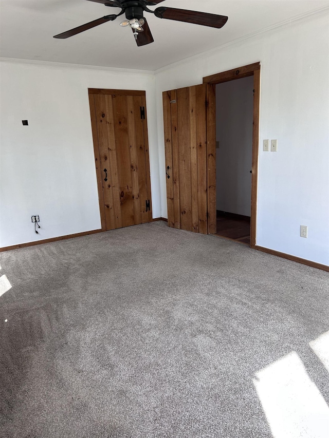 carpeted spare room featuring a ceiling fan and baseboards