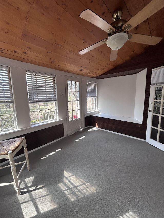 empty room featuring carpet flooring, wood ceiling, a ceiling fan, and vaulted ceiling