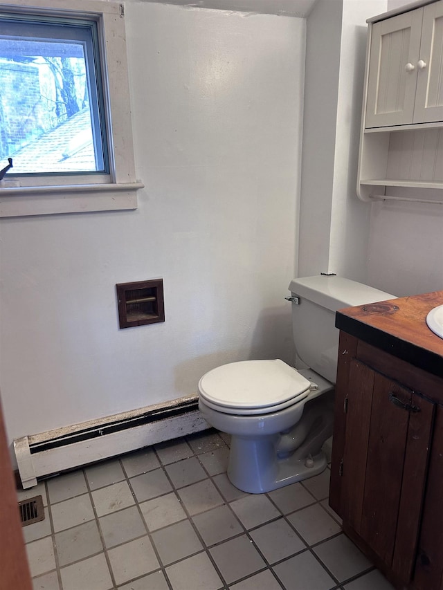 bathroom with vanity, tile patterned floors, baseboard heating, and toilet
