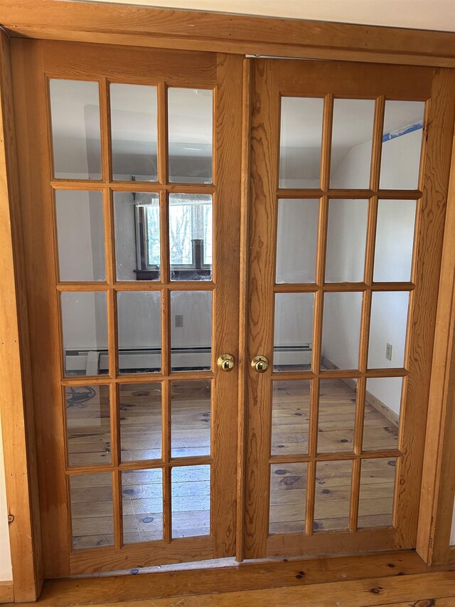 interior details featuring a baseboard radiator, baseboard heating, and wood finished floors