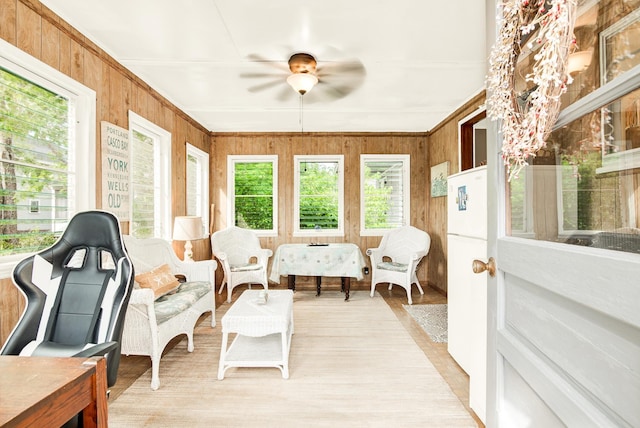 sunroom / solarium featuring wood finished floors and wooden walls