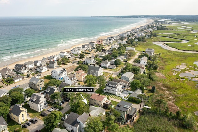 drone / aerial view featuring a water view, a view of the beach, and a residential view